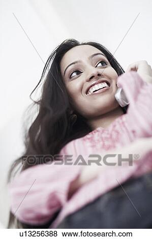 Low angle view of a teenage girl talking on a mobile phone View Large Photo Image Stock Photo - Low angle view of a teenage girl talking on a mobile phone. Fotosearch
