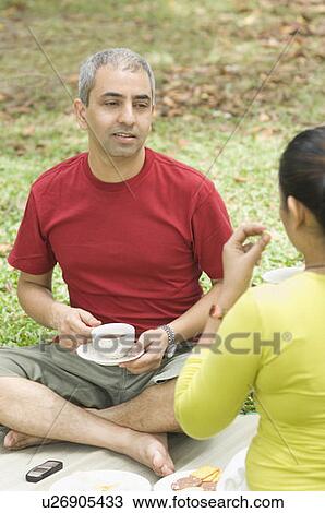 Mid adult couple sitting together and drinking tea View Large Photo Image Stock Image - Mid adult couple sitting together and drinking tea. Fotosearch