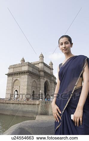 Portrait of a young woman standing with a monument in the background, Gateway Of India, Mumbai, Maharashtra, India View Large Photo Image Stock Image - Portrait of a young woman standing with a monument in the background, Gateway Of India, Mumbai, Maharashtra, India. Fotosearch