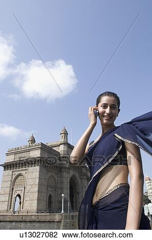 Portrait of a young woman talking on a mobile phone with a monument in the background, Gateway Of India, Mumbai, Maharashtra, India View Large Photo Image Stock Image - Portrait of a young woman talking on a mobile phone with a monument in the background, Gateway Of India, Mumbai, Maharashtra, India. Fotosearch
