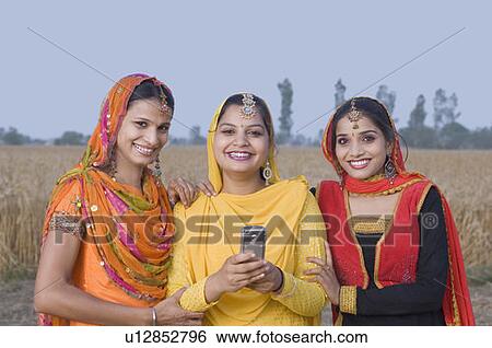 Stock Photograph - Portrait of three young women smiling. Fotosearch