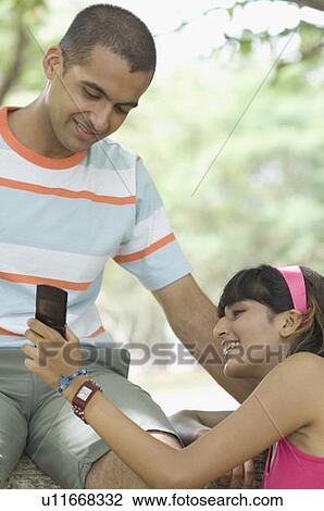 Stock Image - Young couple looking at a mobile phone . Fotosearch