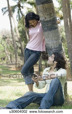 Stock Image - Young couple looking at each other and smiling. Fotosearch