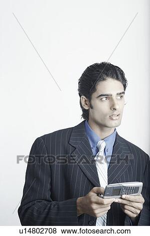 Young man holding a mobile phone View Large Photo Image Stock Photo - Young man holding a mobile phone. Fotosearch