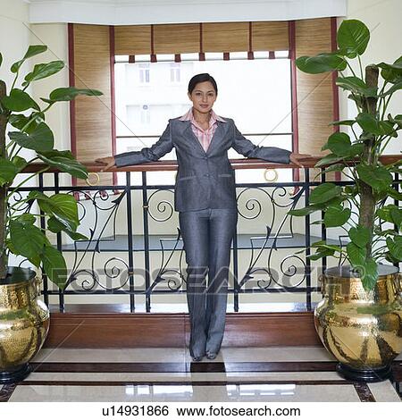 Portrait of a businesswoman leaning against a railing in a hotel View Large Photo Image Stock Photograph - Portrait of a businesswoman leaning against a railing in a hotel. Fotosearch