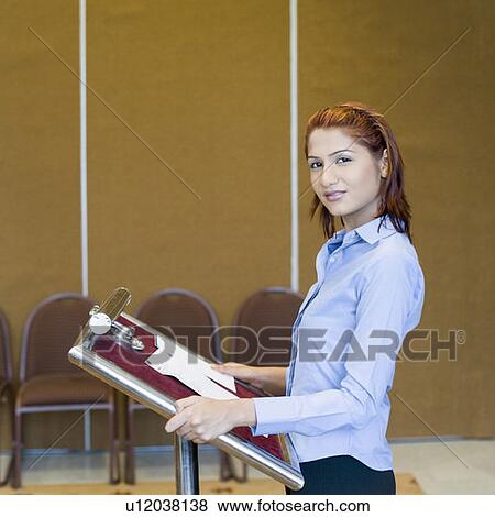Stock Photo - Portrait of a businesswoman standing at a lectern. Fotosearch