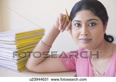 Stock Image - Portrait of a teacher holding a pencil. Fotosearch