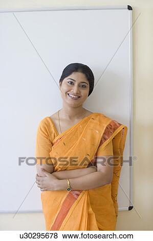 Stock Photo - Portrait of a teacher standing with her arms crossed. Fotosearch