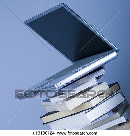 Close-up of a laptop on a stack of books View Large Photo Image Picture - Close-up of a laptop on a stack of books. Fotosearch