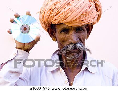 Mature man holding a cd, Pushkar, Rajasthan, India View Large Photo Image Stock Photography - Mature man holding a cd, Pushkar, Rajasthan, India. Fotosearch