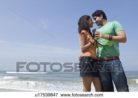 Low angle view of a young man embracing a young woman on the beach View Large Photo Image Stock Photo - Low angle view of a young man embracing a young woman on the beach. Fotosearch