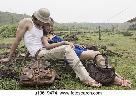 Picture - Portrait of a young woman leaning on a young man on the rock. Fotosearch