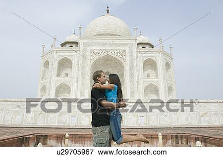 Side profile of a young couple embracing each other in front of a mausoleum, Taj Mahal, Agra, Uttar Pradesh, India View Large Photo Image Stock Photo - Side profile of a young couple embracing each other in front of a mausoleum, Taj Mahal, Agra, Uttar Pradesh, India. Fotosearch