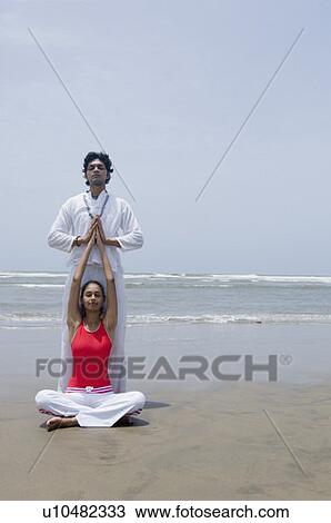 Young couple meditating on the beach View Large Photo Image Stock Image - Young couple meditating on the beach. Fotosearch