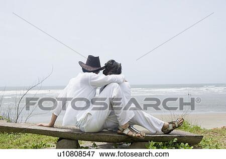 Young couple sitting on a wooden plank on the beach View Large Photo Image Stock Photo - Young couple sitting on a wooden plank on the beach. Fotosearch