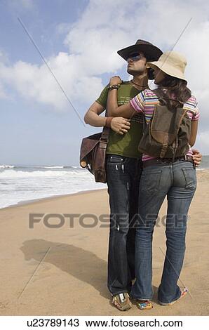 Young couple standing on the beach and embracing each other View Large Photo Image Stock Image - Young couple standing on the beach and embracing each other. Fotosearch