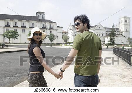 Young couple walking with holding hands, Se Cathedral, Goa, India View Large Photo Image Stock Photograph - Young couple walking with holding hands, Se Cathedral, Goa, India. Fotosearch