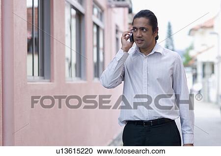 Stock Image - Businessman talking on a mobile phone. Fotosearch