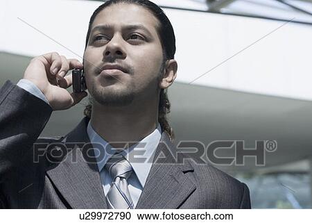 Close-up of a businessman talking on a mobile phone View Large Photo Image Stock Image - Close-up of a businessman talking on a mobile phone. Fotosearch