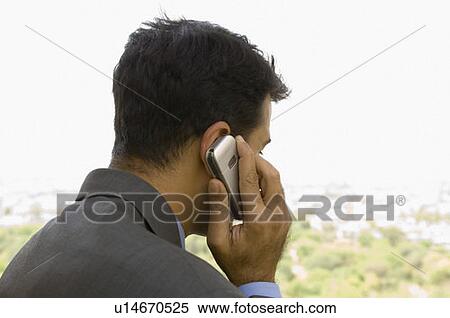 Close-up of a businessman talking on a mobile phone View Large Photo Image Stock Photography - Close-up of a businessman talking on a mobile phone. Fotosearch