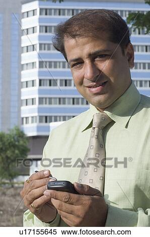Portrait of a businessman using a mobile phone with a stylus View Large Photo Image Stock Photography - Portrait of a businessman using a mobile phone with a stylus. Fotosearch