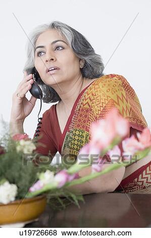 Close-up of a businesswoman talking on a conference phone View Large Photo Image Stock Photo - Close-up of a businesswoman talking on a conference phone. Fotosearch