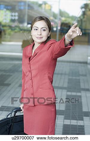 Businesswoman hailing a taxi at an airport View Large Photo Image Stock Photo - Businesswoman hailing a taxi at an airport. Fotosearch