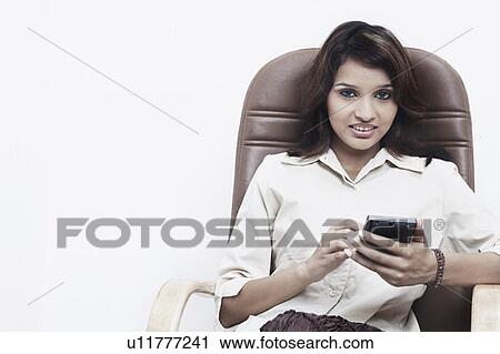 Portrait of a businesswoman holding a personal data assistant View Large Photo Image Stock Image - Portrait of a businesswoman holding a personal data assistant. Fotosearch