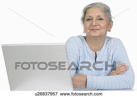 Stock Photo - Portrait of a businesswoman sitting in front of a laptop. Fotosearch