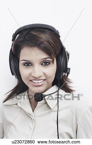 Stock Image - Portrait of a businesswoman wearing a headset smiling. Fotosearch