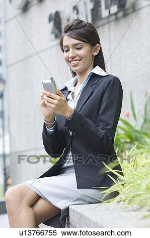 Side profile of a businesswoman using a palmtop and smiling View Large Photo Image Stock Photography - Side profile of a businesswoman using a palmtop and smiling. Fotosearch