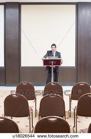 Businessman standing at a lectern View Large Photo Image Picture - Businessman standing at a lectern. Fotosearch