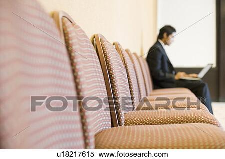 Stock Photography - Businessman working on a laptop in a conference room. Fotosearch
