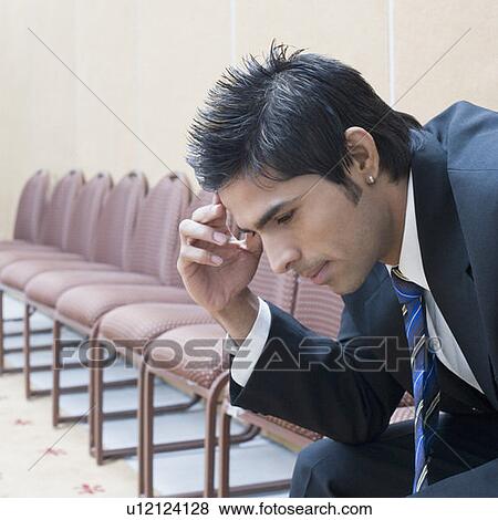 Stock Photo - Side profile of a businessman suffering from a headache. Fotosearch
