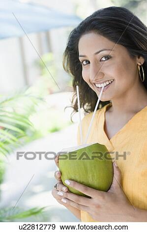 Portrait of a young woman drinking coconut milk View Large Photo Image Stock Photo - Portrait of a young woman drinking coconut milk. Fotosearch