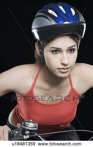 Close-up of a female cyclist riding a bicycle View Large Photo Image Stock Photo - Close-up of a female cyclist riding a bicycle. Fotosearch