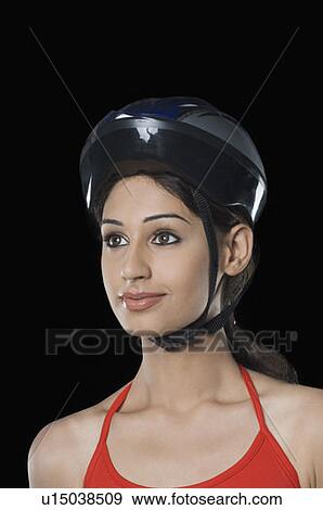 Stock Photo - Close-up of a young woman wearing a cycling helmet. Fotosearch
