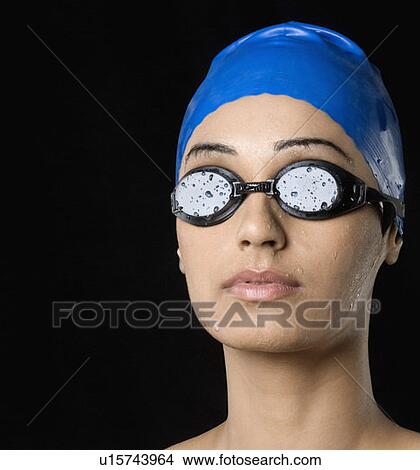 Close-up of a young woman wearing swimming cap and swimming goggles View Large Photo Image Picture - Close-up of a young woman wearing swimming cap and swimming goggles. Fotosearch