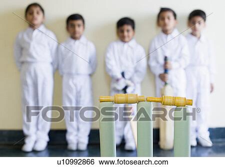 Close-up of cricket stump with cricket players standing in the background View Large Photo Image Stock Photograph - Close-up of cricket stump with cricket players standing in the background. Fotosearch