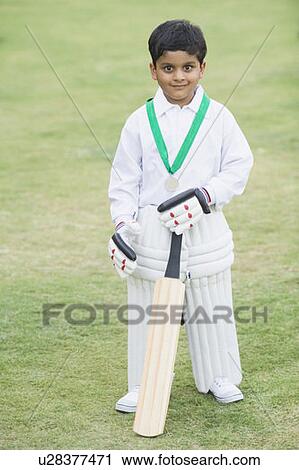 Stock Image - Cricketer standing in a cricket field. Fotosearch