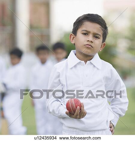 Portrait of a boy holding a cricket ball View Large Photo Image Picture - Portrait of a boy holding a cricket ball. Fotosearch