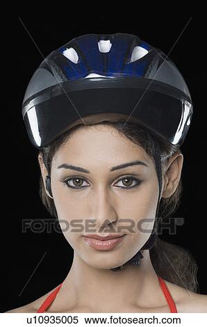Stock Photography - Portrait of a young woman wearing a cycling helmet. Fotosearch