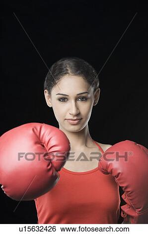 Stock Photograph - Portrait of a young woman wearing boxing gloves. Fotosearch