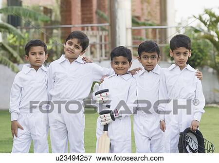 Stock Photo - Portrait of five boys standing in a lawn and smiling. Fotosearch