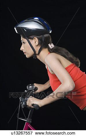 Side profile of a female cyclist riding a bicycle View Large Photo Image Stock Photo - Side profile of a female cyclist riding a bicycle. Fotosearch