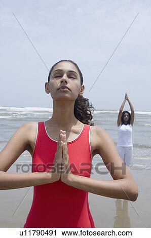 Two young women meditating on the beach View Large Photo Image Stock Image - Two young women meditating on the beach. Fotosearch