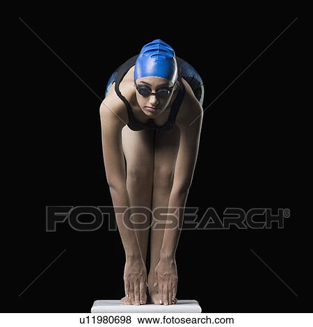 Stock Photo - Young woman taking position on a starting block. Fotosearch