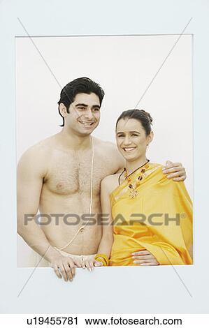 Stock Image - Close-up of a young couple standing near a window. Fotosearch