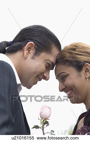 Stock Photography - Side profile of a couple with face to face and smiling. Fotosearch