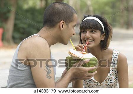 Young couple drinking coconut milk and smiling View Large Photo Image Stock Photo - Young couple drinking coconut milk and smiling. Fotosearch